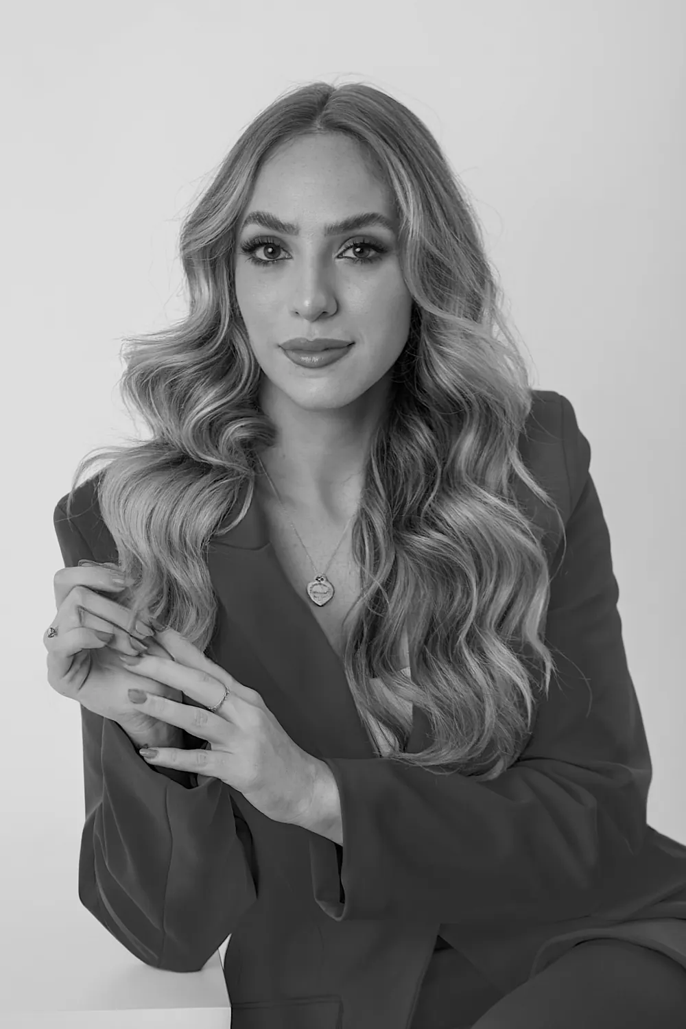 Retrato em preto e branco de Stella Rotenberg, de blazer escuro e cabelos longos ondulados.